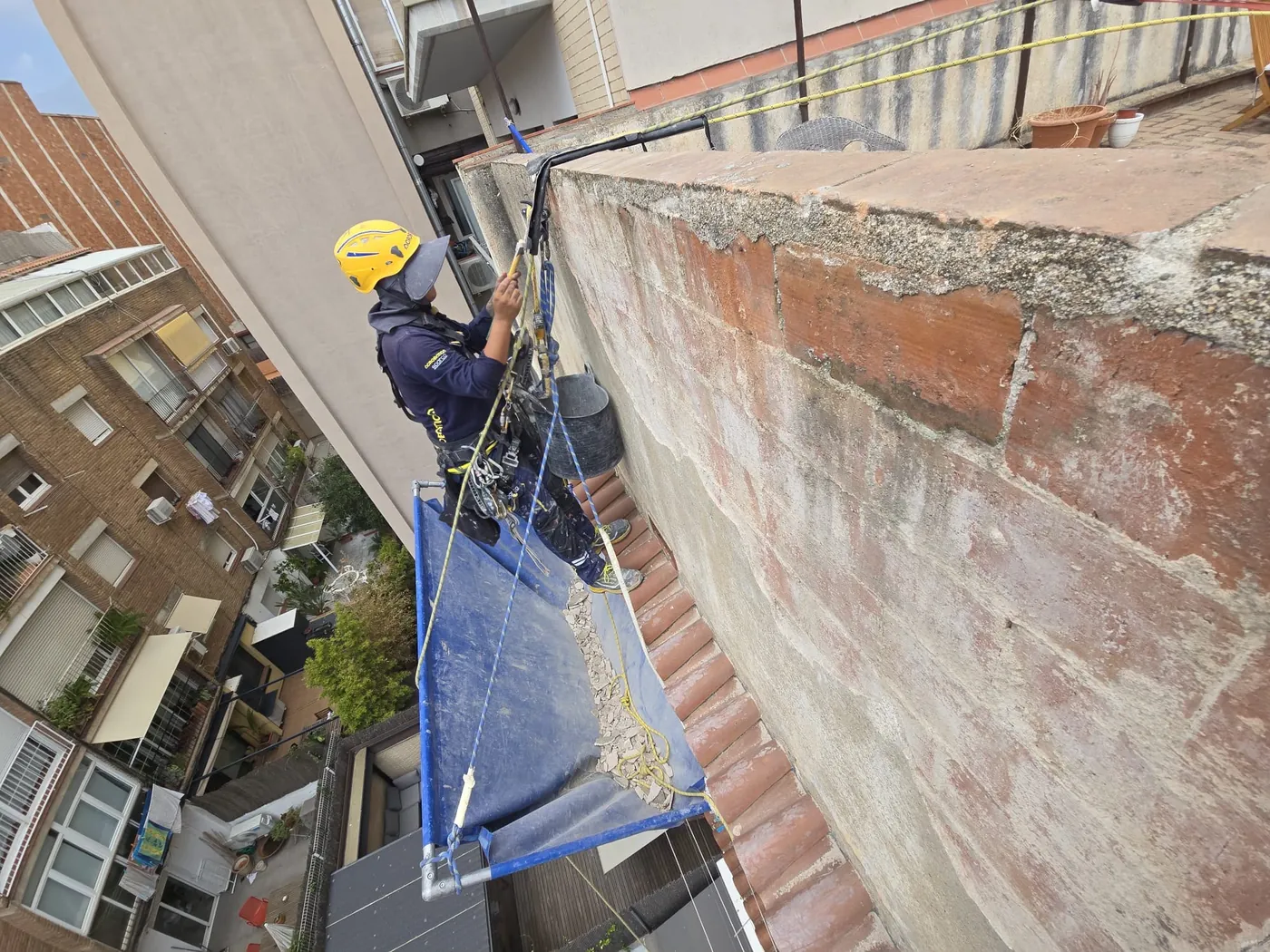 Técnico de Solutions Vertical trabajando con cuerdas en la fachada de un edificio