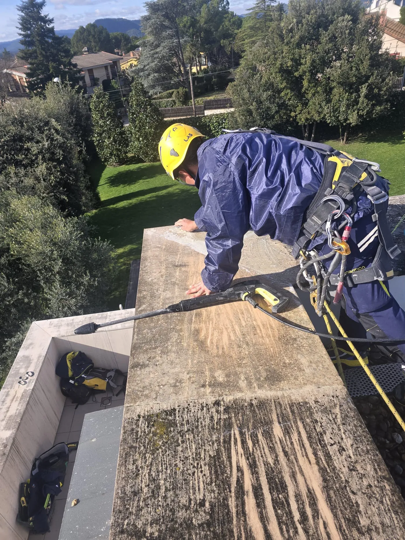 Técnico de Solutions Vertical asegurado con cuerdas trabajando sobre una cornisa