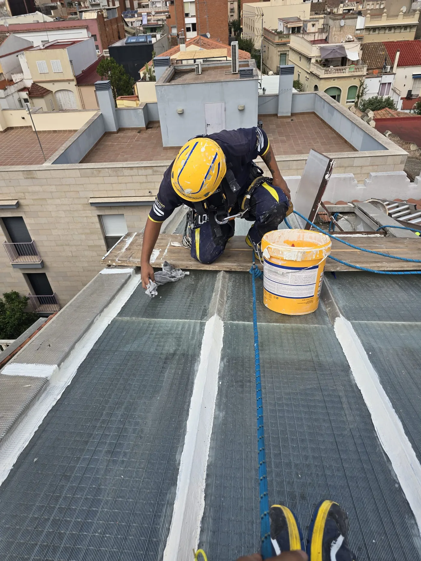 Operario aplicando impermeabilización en la cubierta de un edificio